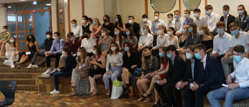 Alle Abiturient:innen mit Masken zum Schutz vor Corona beim Abi-Sekt-Empfang in der Aula